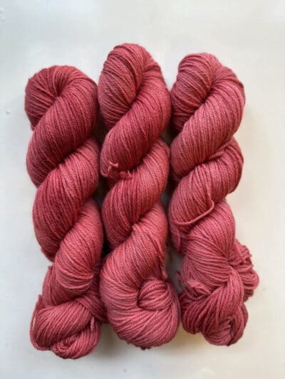 Colorway: Red Dahlia. Length: 256 yards/225 meters. 100 Grams. Experience the beauty of naturally dyed yarn with Light Red Dahlia DK 100% Merino Yarn showcasing a rich red hue.  Crafted from 100% superwash Merino wool, this 4-ply naturally-dyed yarn showcases a rich red hue. Perfect for knitting or crocheting projects, Light Red Dahlia  DK 100% Merino wool yarn is sourced from Uruguay. Elevate your creations with this exquisite and sustainable yarn. Care Instructions: Machine wash on a gentle cycle using mild detergent. Do not bleach. Dry flat away from direct sunlight. Machine washable and easy to care for. Care Instructions: Machine wash on a gentle cycle using mild detergent. Do not bleach. Dry flat away from direct sunlight. While our team hand-dyes each skein with the utmost care, natural dyes results can vary based on plant materials and fibers. Please be aware that variations in color and appearance may vary from the display image.