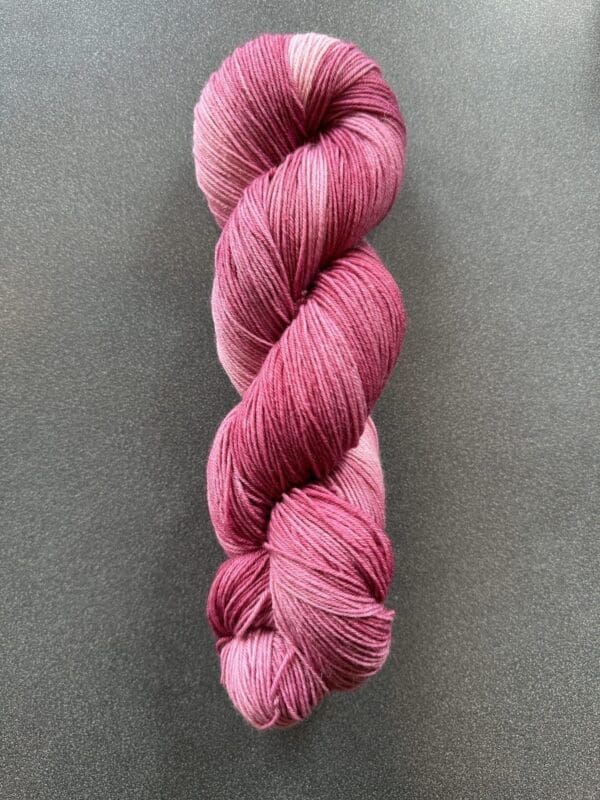 Colorway: Hibiscus.  Length: 437 yds / 400 meters. 100 Grams. Our Variegated Hibiscus wool yarn is a naturally dyed variation in our pink colorway. Sock yarn. Made from 75% Superwash Merino Wool and 25% Recycled Nylon, this 4-ply yarn from Uruguay is strong and light. Perfect for everyday garment projects. Length: 437 yds / 400 meters   <table width="472"> <tbody> <tr> <td><strong>Metric</strong></td> <td><strong>US Knitting Needle</strong></td> <td><strong>Crochet Hook</strong></td> </tr> <tr> <td style="font-style: inherit; font-weight: inherit;">3.25 mm</td> <td style="font-style: inherit; font-weight: inherit;">US 1-2</td> <td style="font-style: inherit; font-weight: inherit;">D3</td> </tr> </tbody> </table>   <table width="472"> <tbody> <tr> <td><strong>Stitches per Inch</strong></td> </tr> <tr> <td style="font-style: inherit; font-weight: inherit;">30 st/4″ or 7-8 st/1″</td> </tr> </tbody> </table> Machine washable and easy to care for. Care Instructions: Machine wash on a gentle cycle using mild detergent. Do not bleach. Dry flat away from direct sunlight. <strong>While our team hand-dyes each skein with the utmost care, natural dyes results can vary based on plant materials and fibers. Please be aware that variations in color and appearance may vary from the display image.  </strong>