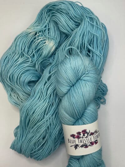 Blue Colorway: Variegated River Orchid. Length: 437 yds / 400 meters. 100g. Variegted River Orchid Sock yarn, a 4-ply naturally dyed variegated blue-green blend of 75% Superwash Merino and 25% nylon. This Peru-origin yarn is hand-dyed using plant-based dyes, resulting in an eco-friendly option. Perfect for knitting or crocheting projects. Care Instructions: Hand wash in cold water with a gentle detergent made specifically for washing wool and other fine fibers, or a PH-neutral, dye free detergent. Lay flat to dry. While our team hand-dyes each skein with the utmost care, natural dyes results can vary based on plant materials and fibers. Please be aware that variations in color and appearance may vary from the display image.  Please wash before using, as naturally dyed fibers can run the first few washings. Please be aware that variations in color and appearance may vary from the display image.  