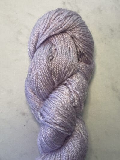 Purple Colorway: Variegated Lavender. Length: 383 yards | 350 m | 100 g Variegated Lavender eco-sock 4 ply wool yarn is made from 50% Recycled Wool & 50% Tencel for durability.  This variegated colorway has a white streak entwined with lavender. This sustainable yarn is ethically sourced from Peru and naturally dyed in West Virginia.  This wool has a crisp, bulky feel and is perfect for apparel and other projects.  