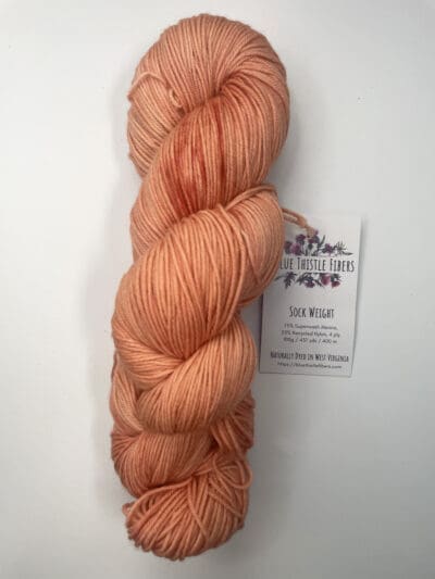 Orange Colorway: Variegated Dark Pumpkin Spice Sockk. Length: 437 yds / 400 meters. 100 Grams. Variegated Dark Pumpkin Spice Sock 4-ply sock yarn, a naturally dyed blend of 75% Superwash Merino and 25% nylon. This Peru-origin yarn is hand-dyed using plant-based dyes, resulting in an eco-friendly option. Perfect for knitting or crocheting projects. Care Instructions: Hand wash in cold water with a gentle detergent made specifically for washing wool and other fine fibers, or a PH-neutral, dye free detergent. Lay flat to dry. <strong>While our team hand-dyes each skein with the utmost care, natural dyes results can vary based on plant materials and fibers. Please be aware that variations in color and appearance may vary from the display image.  </strong>  