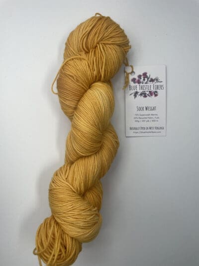 Yellow Colorway: Variegated Dark Gold. Length: 437 yds / 400 meters. 100 Grams. Variegated Dark Gold Sock 4-ply sock yarn, a naturally dyed blend of 75% Superwash Merino and 25% nylon. This Peru-origin yarn is hand-dyed using plant-based dyes, resulting in an eco-friendly option. Perfect for knitting or crocheting projects. Care Instructions: Hand wash in cold water with a gentle detergent made specifically for washing wool and other fine fibers, or a PH-neutral, dye free detergent. Lay flat to dry. <strong>While our team hand-dyes each skein with the utmost care, natural dyes results can vary based on plant materials and fibers. Please be aware that variations in color and appearance may vary from the display image.  </strong>  