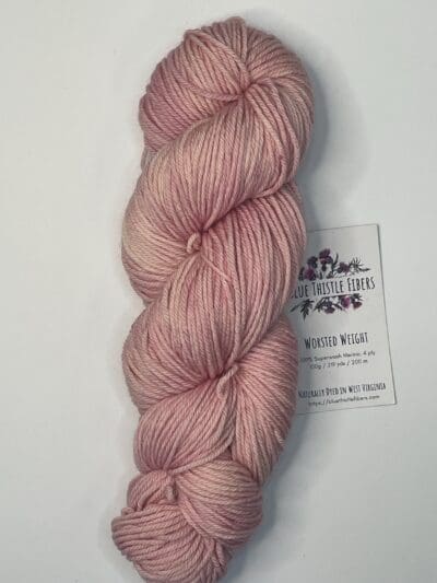 Pink Colorway: Variegated Rose. 219 yards / 200 meters. 100 grams Variegated Rose Worsted 4-ply  yarn is naturally dyed with sustainably harvested/foraged dye material from plants, minerals, roots, trees, and other organic materials. Blue Thistle Fiber’s 4-ply Worsted yarn is certified mulesing-free SW 100% Merino wool and quickly works up into hats and sweaters everyone will love to wear. A durable yarn that holds up to washing and wearing. Care Instructions: Machine wash on a gentle cycle using mild detergent. Do not bleach. Dry flat away from direct sunlight. <strong>While our team hand-dyes each skein with the utmost care, natural dyes results can vary based on plant materials and fibers. </strong><strong>Please wash before using, as naturally dyed fibers can run the first few washings.</strong> <strong>Please be aware that variations in color and appearance may vary from the display image.</strong>  