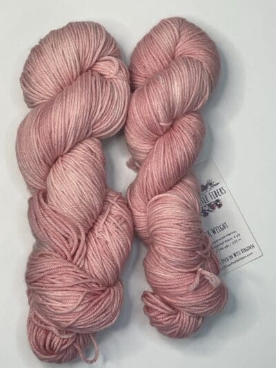 Pink Colorway: Rose. Length: 246 yds / 225 meters. 100 Grams. Our Variegated Rose DK wool yarn is a naturally dyed variation in our pink colorway.  This 4-ply yarn has the perfect combination of warmth and durability. 75% Superwash Merino wool / 25% Recycled Nylon, sourced directly from Uruguay, has excellent insulation properties and adds structure, that provides the strength and lightness it needs for heavy-duty wear. Our naturally dyed DK yarn is an excellent choice for soft and durable sweaters, baby clothes, and boot socks, just to name a few possible uses for this versatile yarn. Machine washable and easy to care for. Care Instructions: Machine wash on a gentle cycle using mild detergent. Do not bleach. Dry flat away from direct sunlight. While our team hand-dyes each skein with the utmost care, natural dyes results can vary based on plant materials and fibers. Please be aware that variations in color and appearance may vary from the display image.